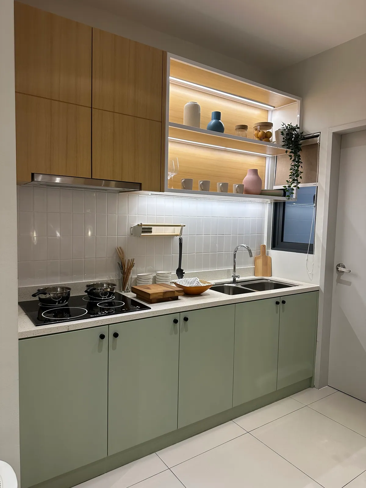 Open timber shelving, green cabinets and integrated shelf lighting.